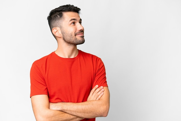 Beau jeune homme caucasien sur fond blanc isolé regardant sur le côté