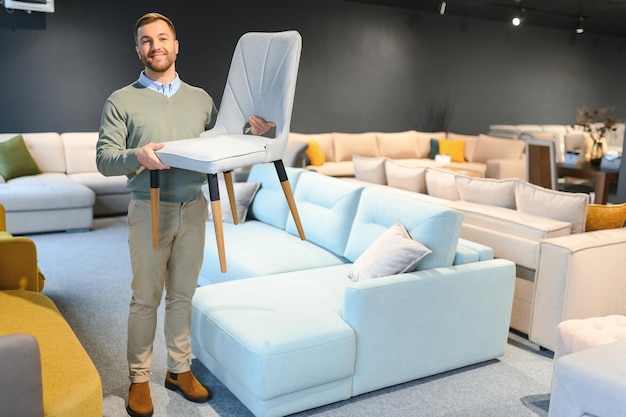 Photo un beau jeune homme choisit des meubles dans un magasin.