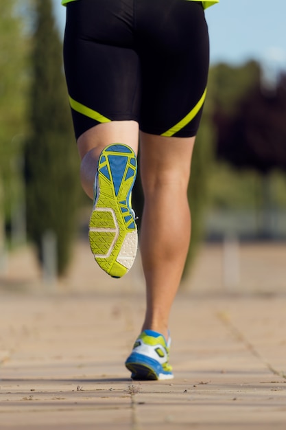 Photo beau jeune homme courir dans le parc.