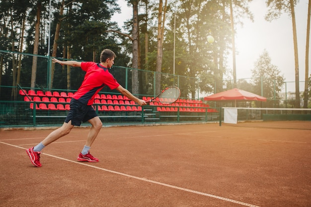 beau jeune homme sur un court de tennis.