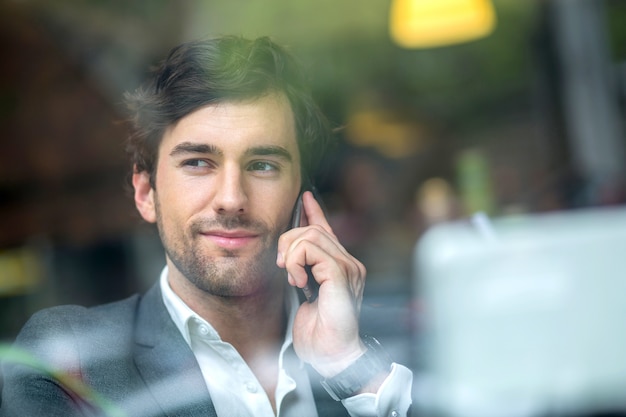 Un beau jeune homme dans la fenêtre