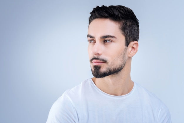 beau jeune homme debout contre le mur bleu