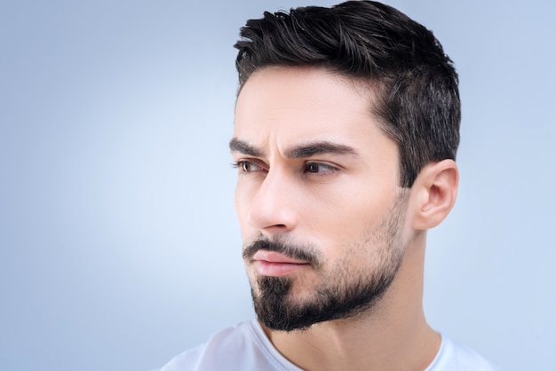 beau jeune homme debout contre le mur bleu