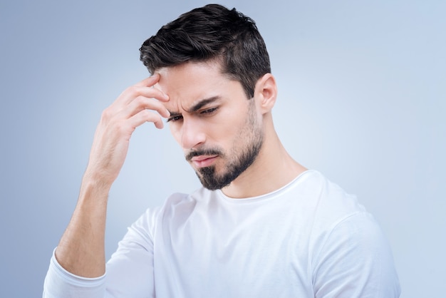 beau jeune homme debout contre le mur bleu