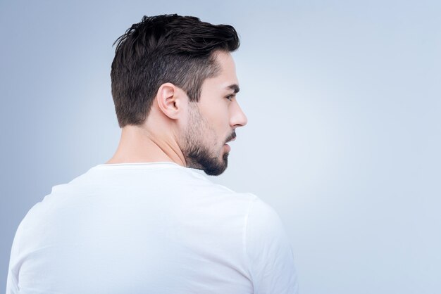 beau jeune homme debout contre le mur bleu