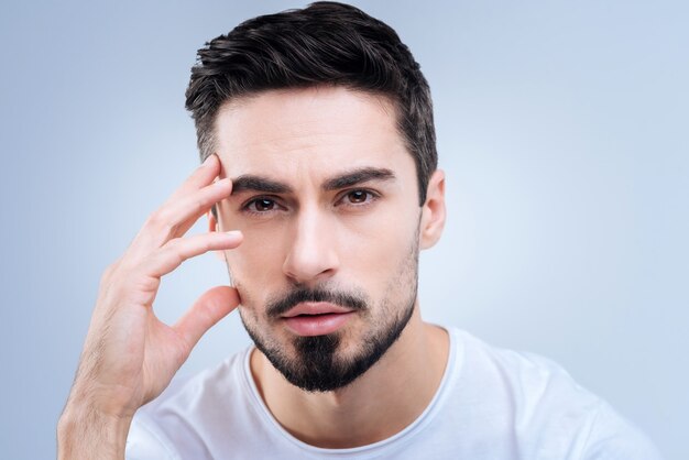 beau jeune homme debout contre le mur bleu