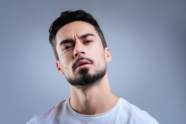 beau jeune homme debout contre le mur bleu