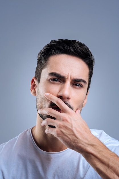 beau jeune homme debout contre le mur bleu