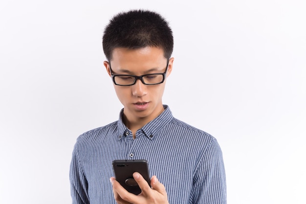 Beau jeune homme faisant un appel téléphonique isolé sur fond blanc