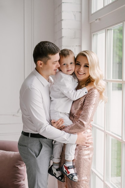 Beau jeune homme de famille femme et fils dans des vêtements intelligents dans un luxueux intérieur lumineux famille heureuse