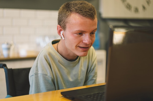 Un beau jeune homme handicapé qui parle au téléphone portable en kittchen, une personne handicapée.