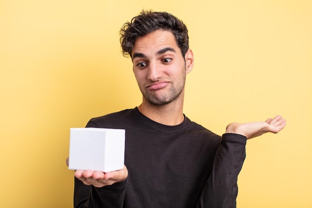 beau jeune homme hispanique tenant une boîte blanche