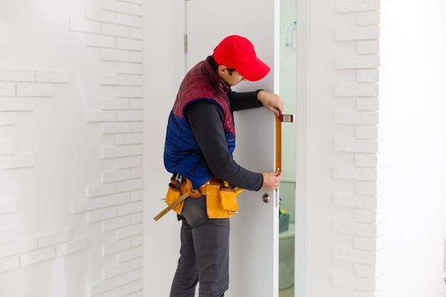 beau jeune homme installant une porte dans un nouveau chantier de construction de maison