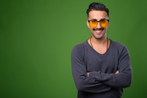 Beau jeune homme iranien avec moustache sur vert