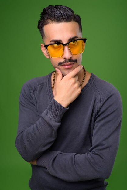 Beau jeune homme iranien avec moustache sur vert