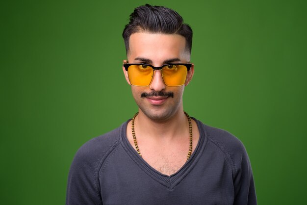 Beau jeune homme iranien avec moustache sur vert