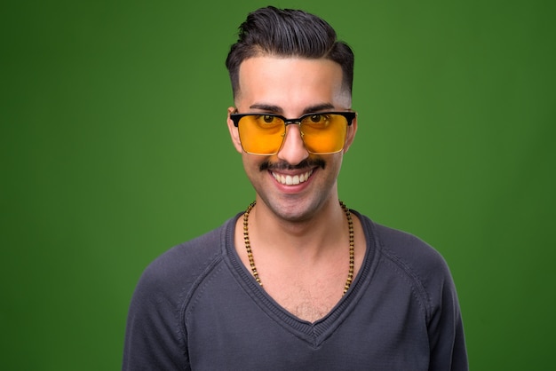 Beau jeune homme iranien avec moustache sur vert
