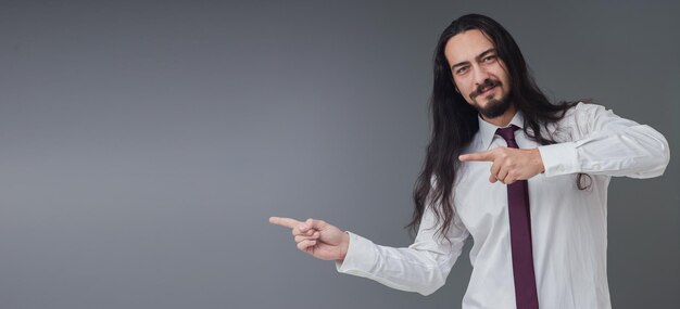 Beau jeune homme italien montre l'espace vide avec ses mains comprend un espace de copie