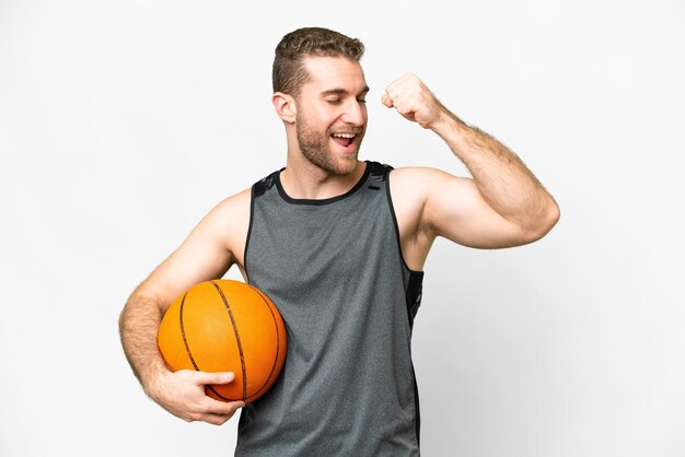 Beau jeune homme jouant au basket-ball sur fond blanc isolé célébrant une victoire