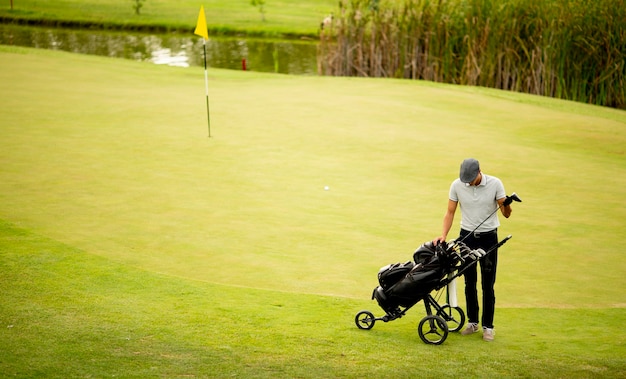 Beau jeune homme jouant au golf