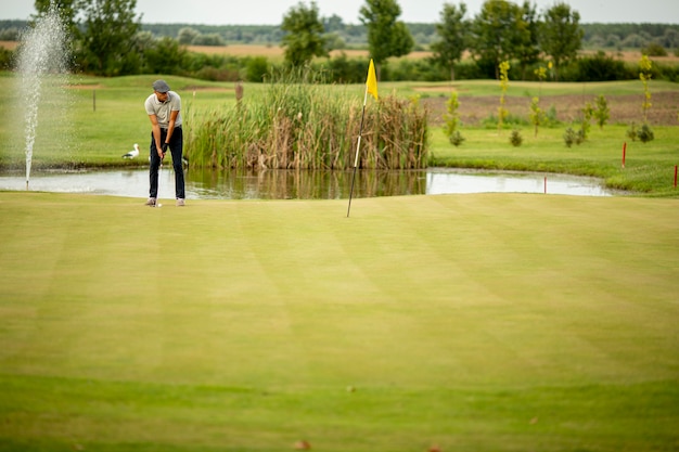 Beau jeune homme jouant au golf