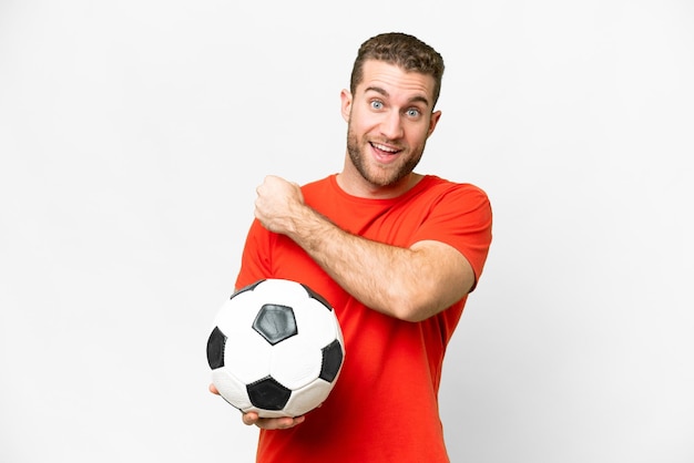 Beau jeune homme de joueur de football sur fond blanc isolé célébrant une victoire