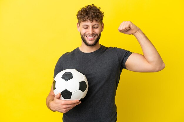 Beau jeune homme de joueur de football isolé sur fond jaune faisant un geste fort