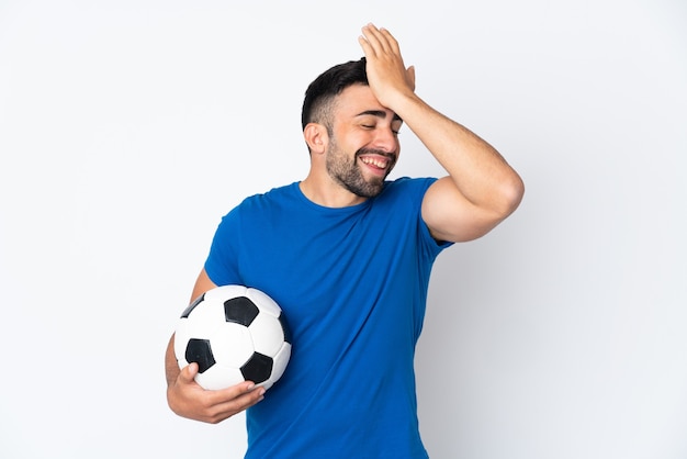 Beau jeune homme joueur de football sur un mur isolé a réalisé quelque chose et a l'intention de la solution