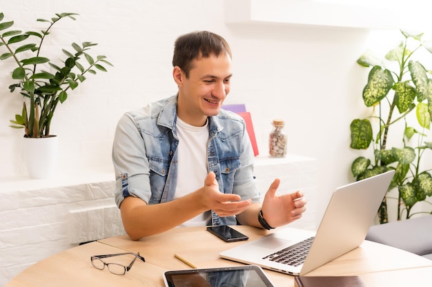 Beau jeune homme en ligne à l'aide d'un ordinateur portable