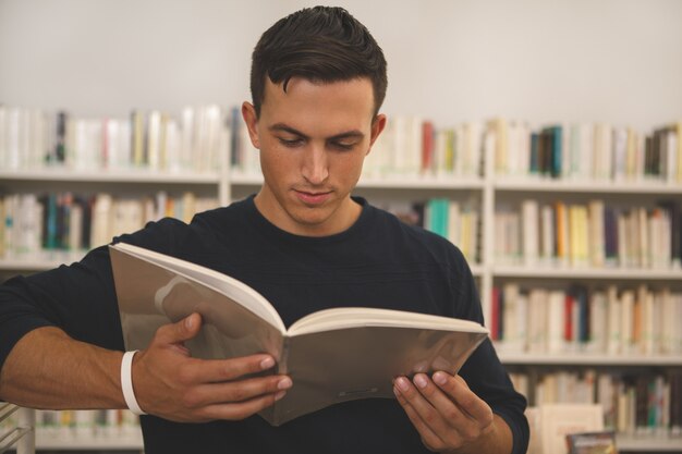 Beau Jeune Homme Lisant à La Bibliothèque