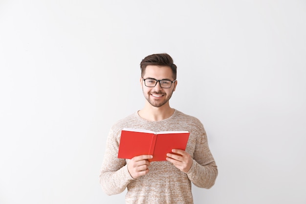 Beau jeune homme avec un livre sur la lumière