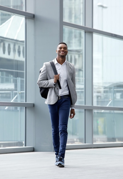 Beau jeune homme marchant à la gare avec sac