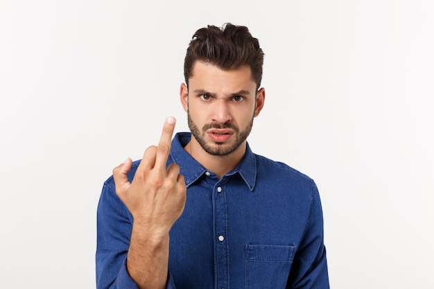 Beau jeune homme montrant le doigt du milieu gesticulant vous vis avec du blanc