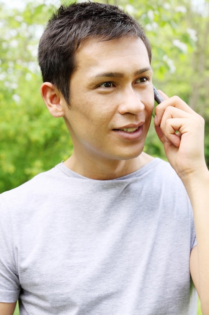 Beau Jeune Homme Parle Sur Un Téléphone Portable