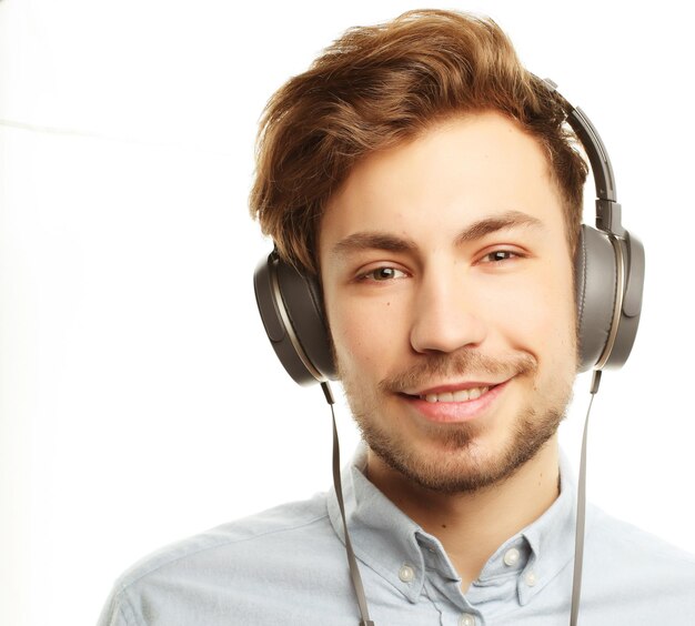 Beau jeune homme portant des écouteurs et écouter de la musique