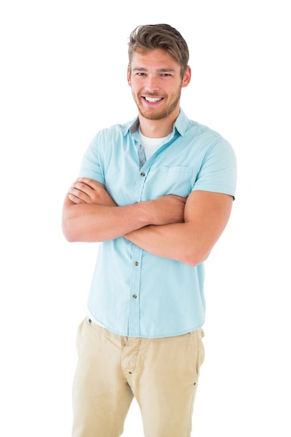 Beau jeune homme posant avec les bras croisés