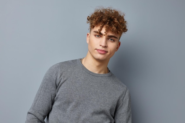 Beau jeune homme posant des vêtements élégants modèle fond isolé