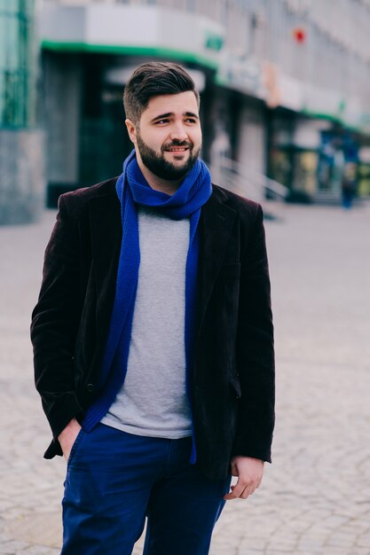 Beau jeune homme sur une promenade en ville