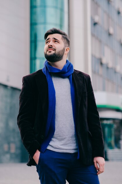 Beau jeune homme sur une promenade en ville