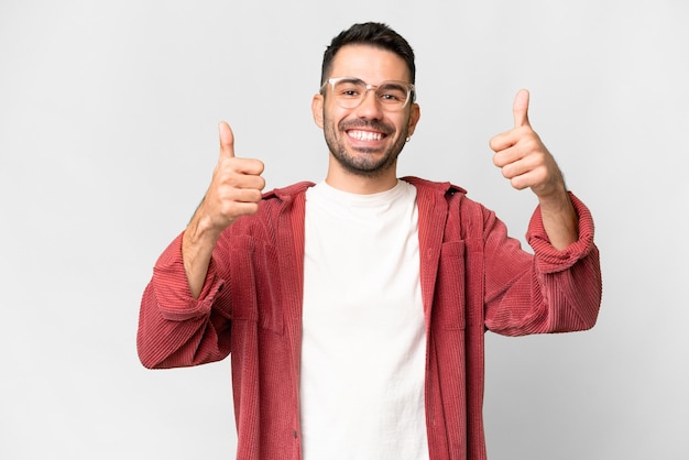 Beau jeune homme de race blanche sur fond blanc isolé donnant un coup de pouce geste