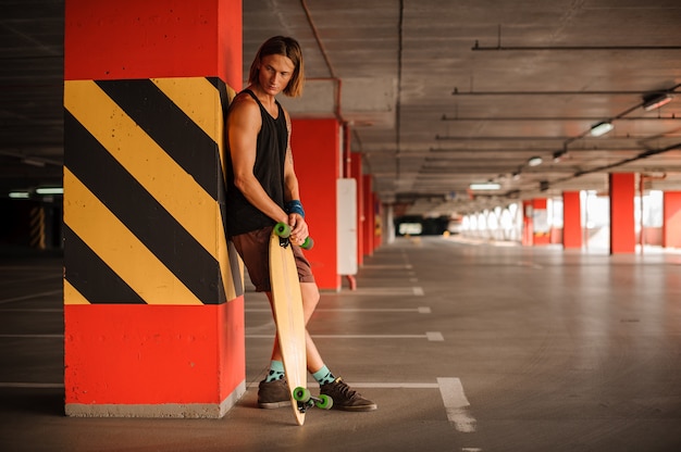 Beau jeune homme rousse avec un longboard