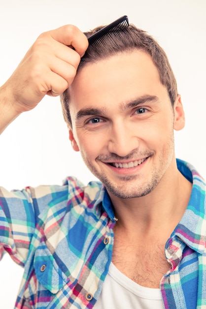 Beau jeune homme se peignant les cheveux