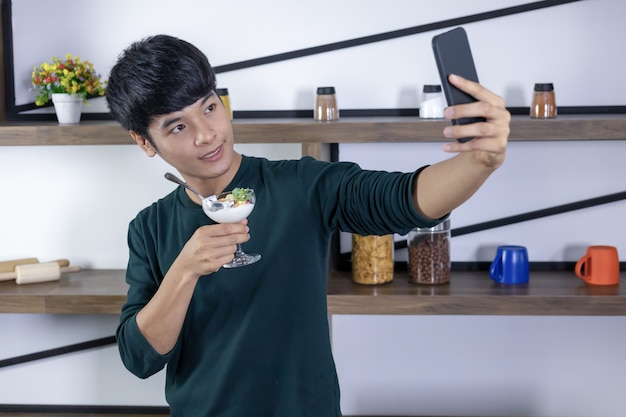 Beau jeune homme selfie heureusement dans la cuisine