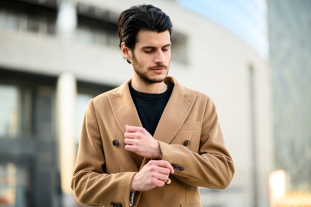 Beau jeune homme souriant en plein air dans des vêtements élégants décontractés