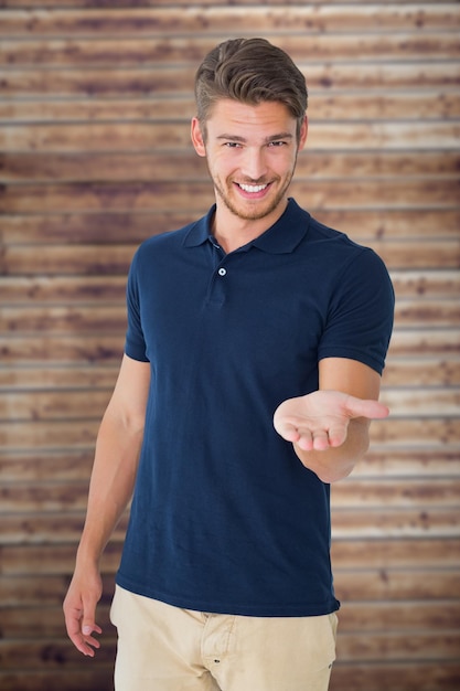 Beau jeune homme tenant sa main contre des planches de bois