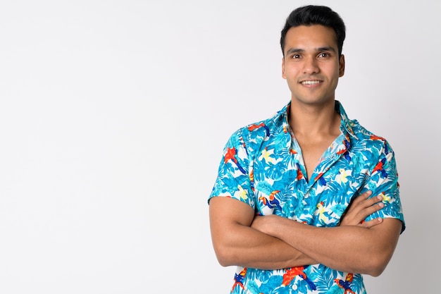 Beau jeune homme touriste indien contre le mur blanc