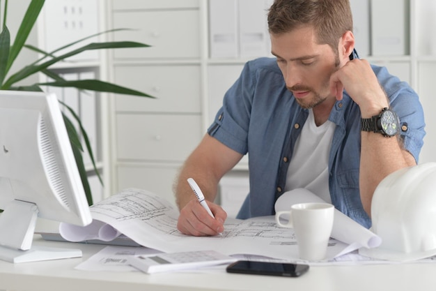 Beau jeune homme travaillant au bureau