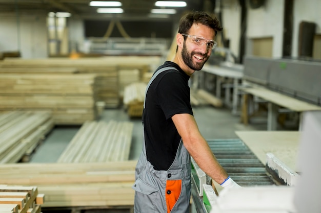 Beau jeune homme travaillant dans l&#39;usine de bois