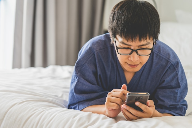 Beau jeune homme en utilisant le téléphone