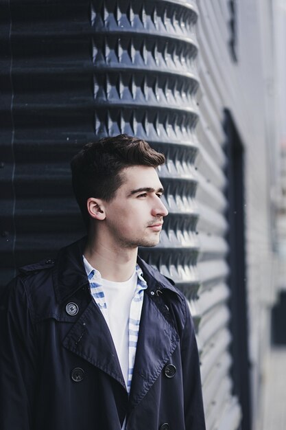 Beau jeune homme en vêtements décontractés regarde ailleurs